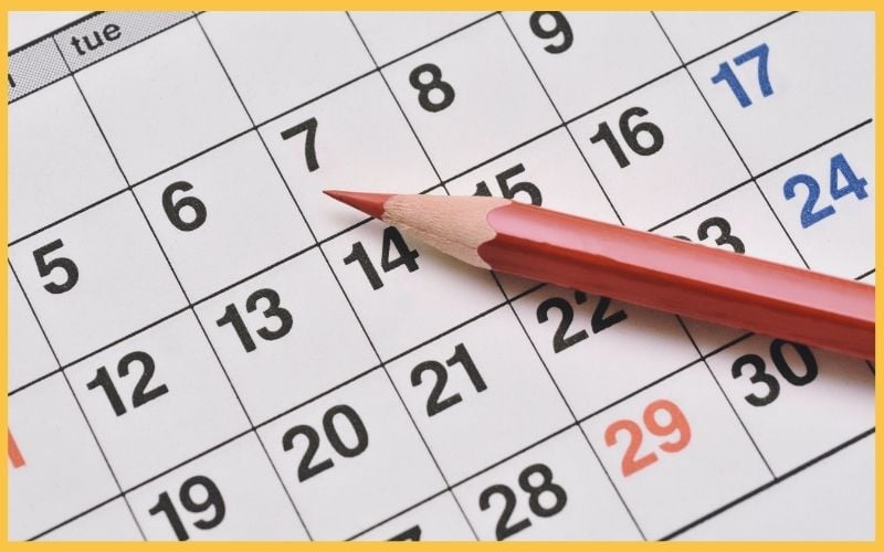 A close-up of a calendar page with a red pencil to symbolize cleaning schedule.