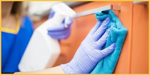 A professional cleaning service in Houston using microfiber cloth and spray to clean.