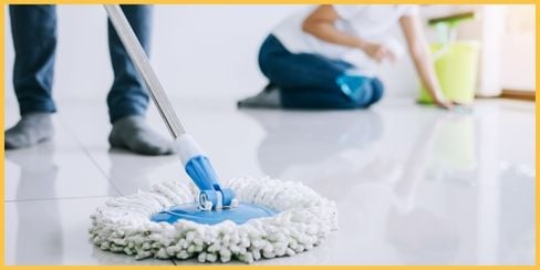 Hellamaid, the best professional cleaning service in Houston, Texas, mopping and scrubbing the floor.