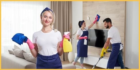 Professional cleaning team tidying a house's living area.